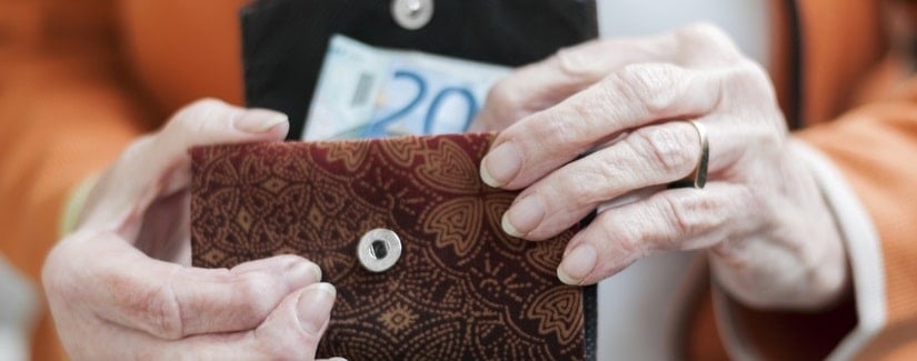 Mains de femme âgée tenant un porte-monnaie