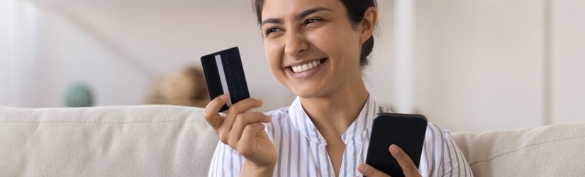 Heureux belle femme dépense bonus cashback reçu sur carte de crédit pour Internet payer