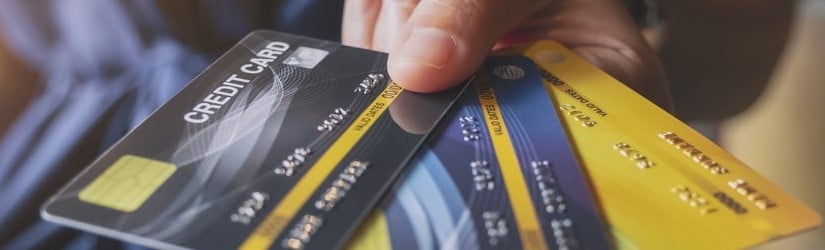 Image en gros plan d'une femme tenant et montrant des cartes de crédit.
